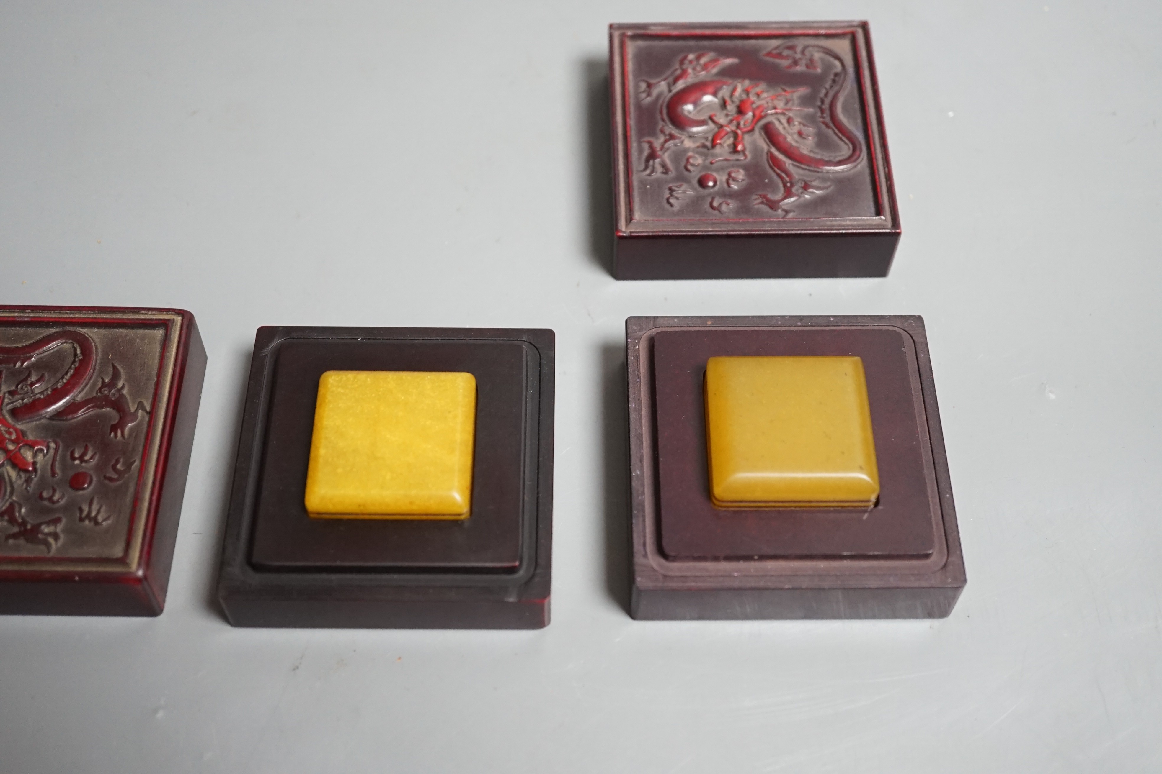 A selection of two oriental seals in dragon relief boxes, 6.5cm wide